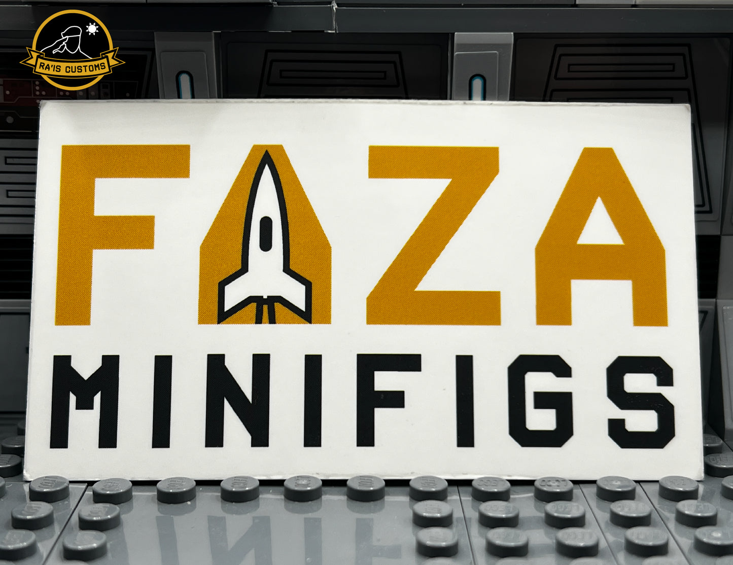 Logo of Faza Minifigs featuring bold yellow and black lettering with a rocket design integrated into the letter 'A,' displayed against a Star Wars-inspired gray diorama background. Showcasing the brand's creative identity for custom LEGO minifigures. Ideal for fans and collectors of high-quality, unique LEGO designs.