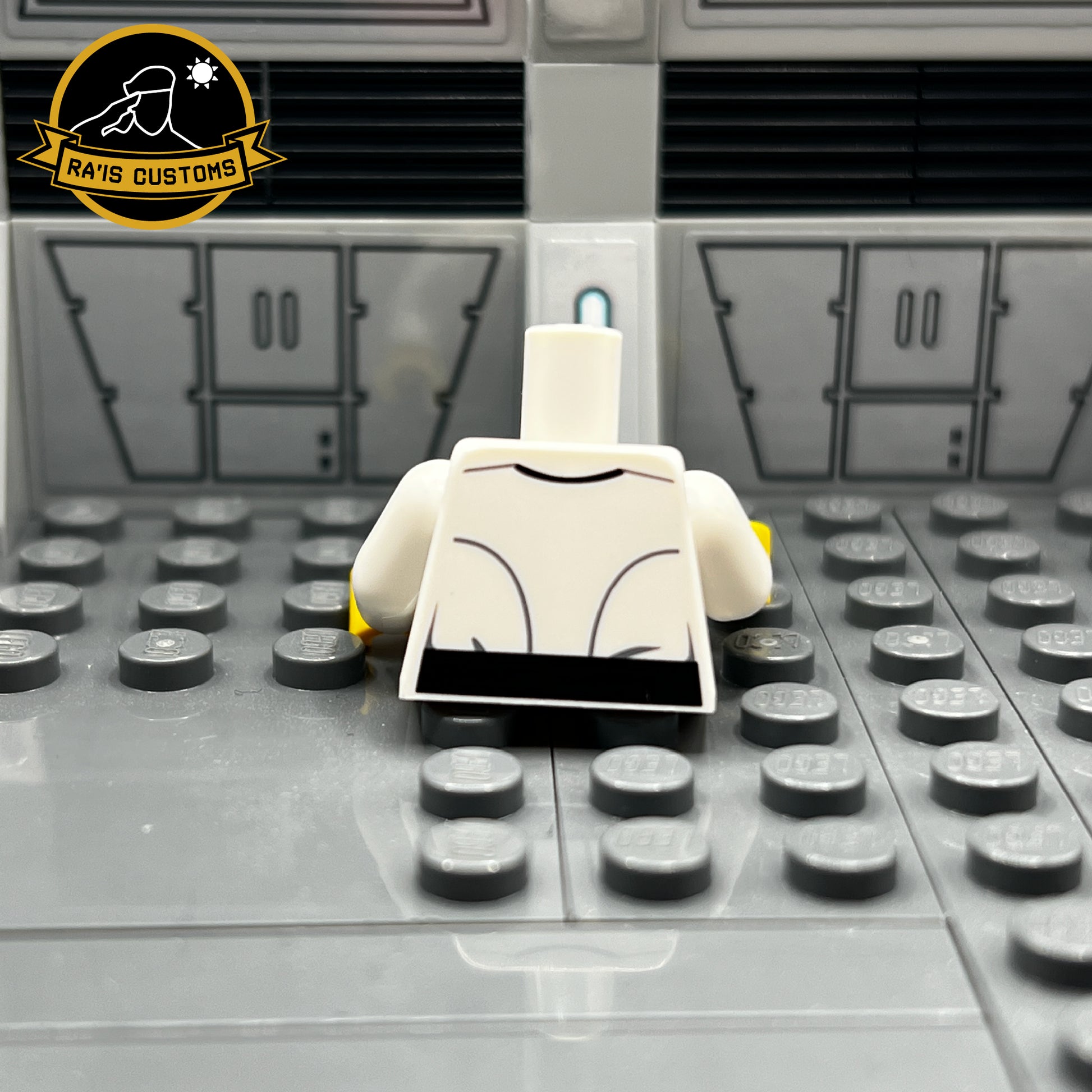 Rear view of a pad-printed custom LEGO torso of a Grand Admiral from Star Wars, created by Ra'is Customs. Inspired by the Star Wars Expanded Universe and Star Wars Legends, including characters like Grand Admiral Thrawn in Legends. Features the clean and accurate design of the iconic white Imperial uniform with black belt detailing. Displayed in a Star Wars-themed diorama with a futuristic gray backdrop, this piece is ideal for fans and collectors of custom LEGO minifigures representing the Galactic Empire.