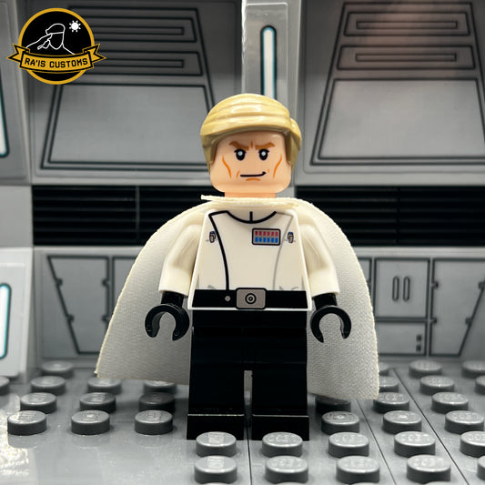 Custom LEGO minifigure of Director Krennic from Star Wars: Rogue One, created by Ra'is Customs. Features detailed design with a white uniform, rank insignia, blonde hairpiece, and iconic white cape. Displayed in a Star Wars-themed diorama with a futuristic gray backdrop. Perfect for Star Wars fans and LEGO collectors seeking high-quality custom minifigures.